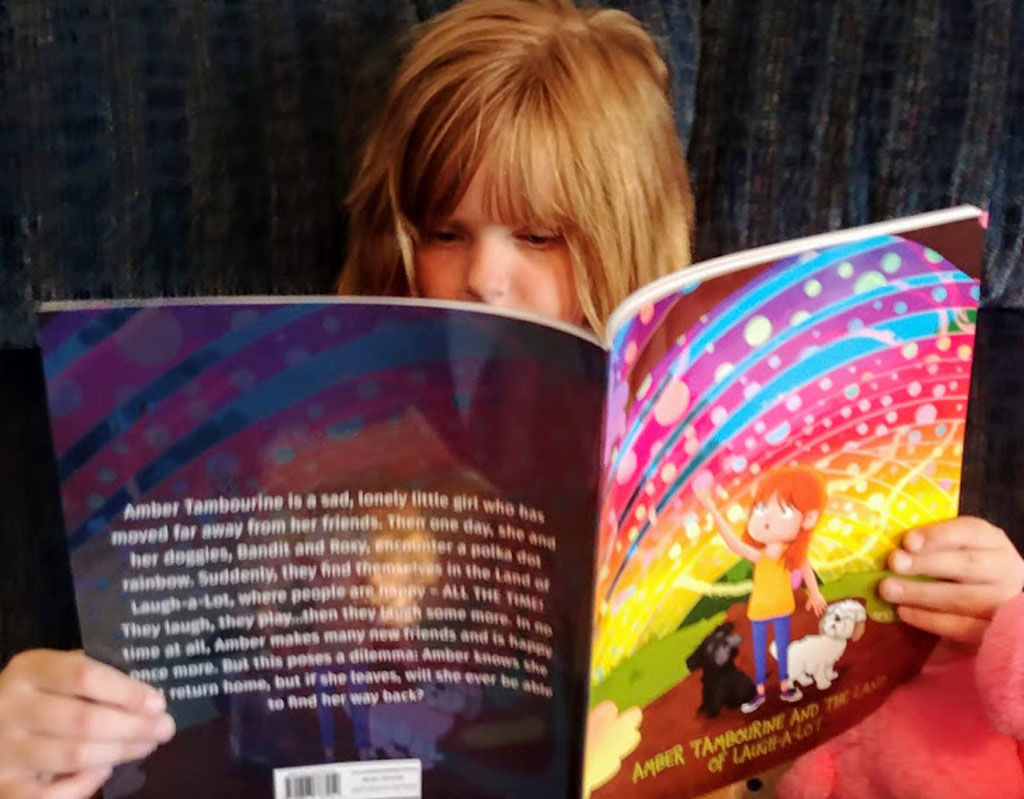 Child reading Aimee C. Trafton's book Amber Tambourine and the Land of Laugh-a-Lot.