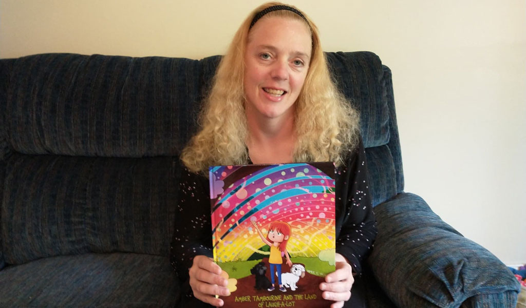 Aimee C. Trafton with her book, Amber Tambourine and the Land of Laugh-a-Lot.